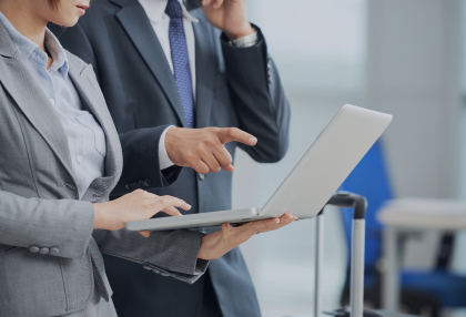 unrecognizable-man-woman-business-suits-looking-laptop-screen-together 1